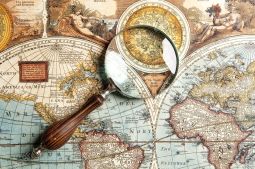 21145611-Magnifying-glass-and-ancient-old-map-Stock-Photo-world